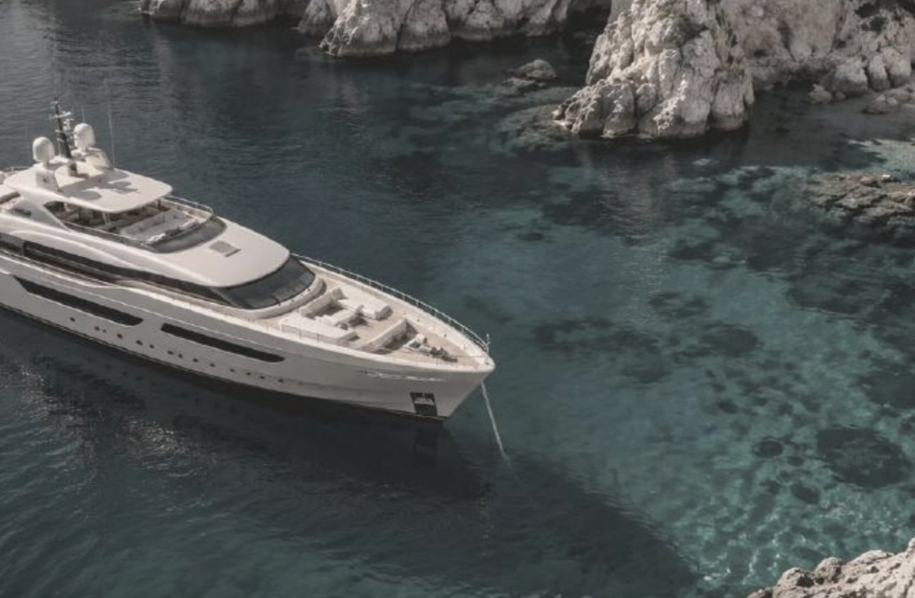 Motor yacht at anchor in a rocky bay